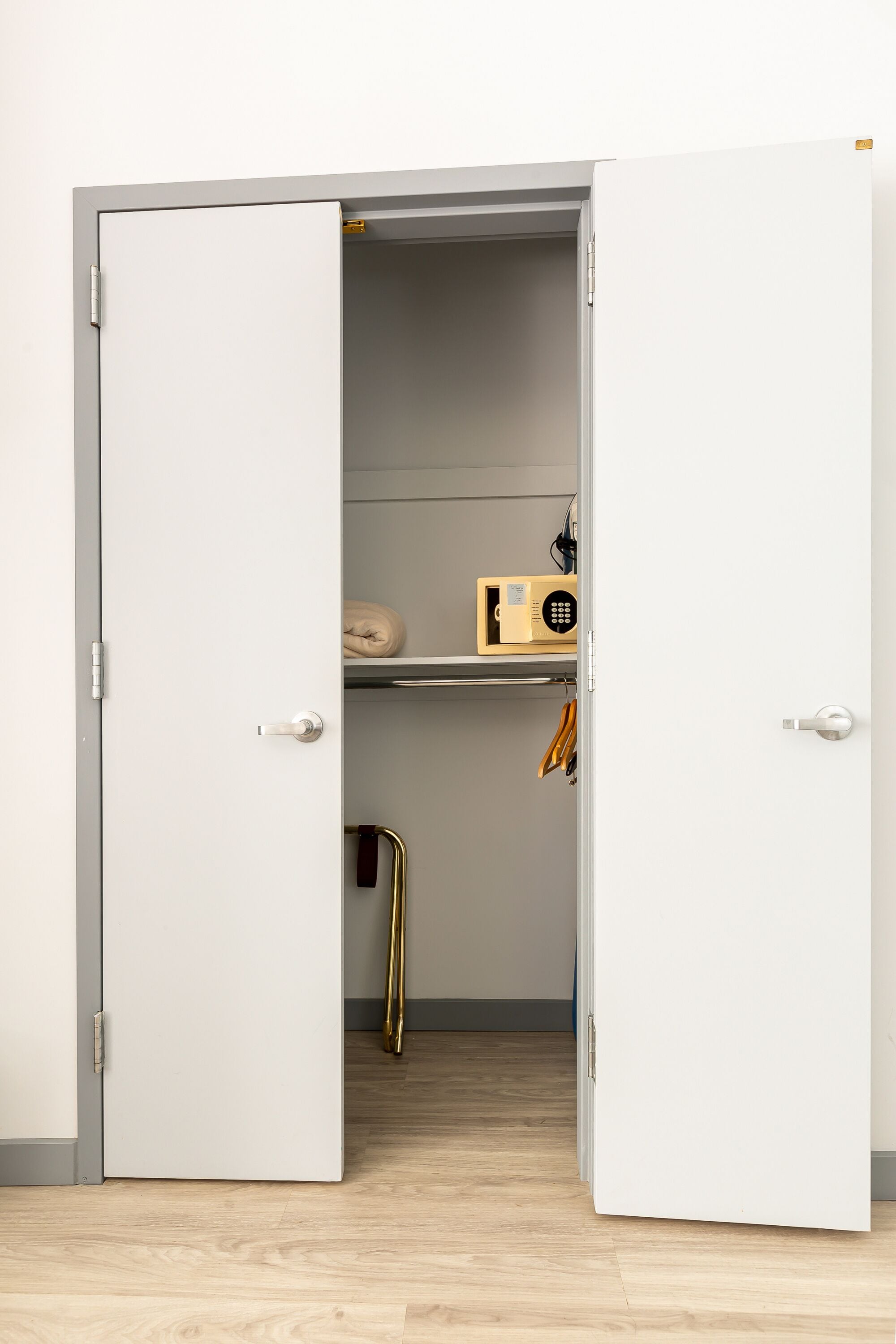 A white door leading to a storage closet with shelves and a radio.