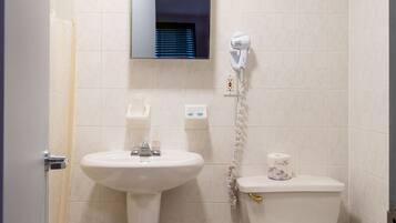A bathroom with a pedestal sink, toilet, and a mirror above the sink.