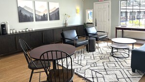 Un espace de détente moderne comprenant une table à manger, des chaises, un canapé et un coin café.