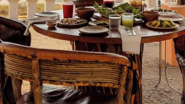 Una mesa dispuesta para comer con vistas a la playa y el océano.