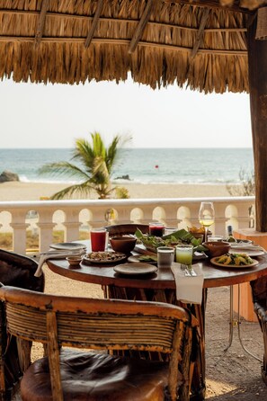 A table set for dining with a view of the beach and ocean. - Hotel Santa Fe (Puerto Escondido)