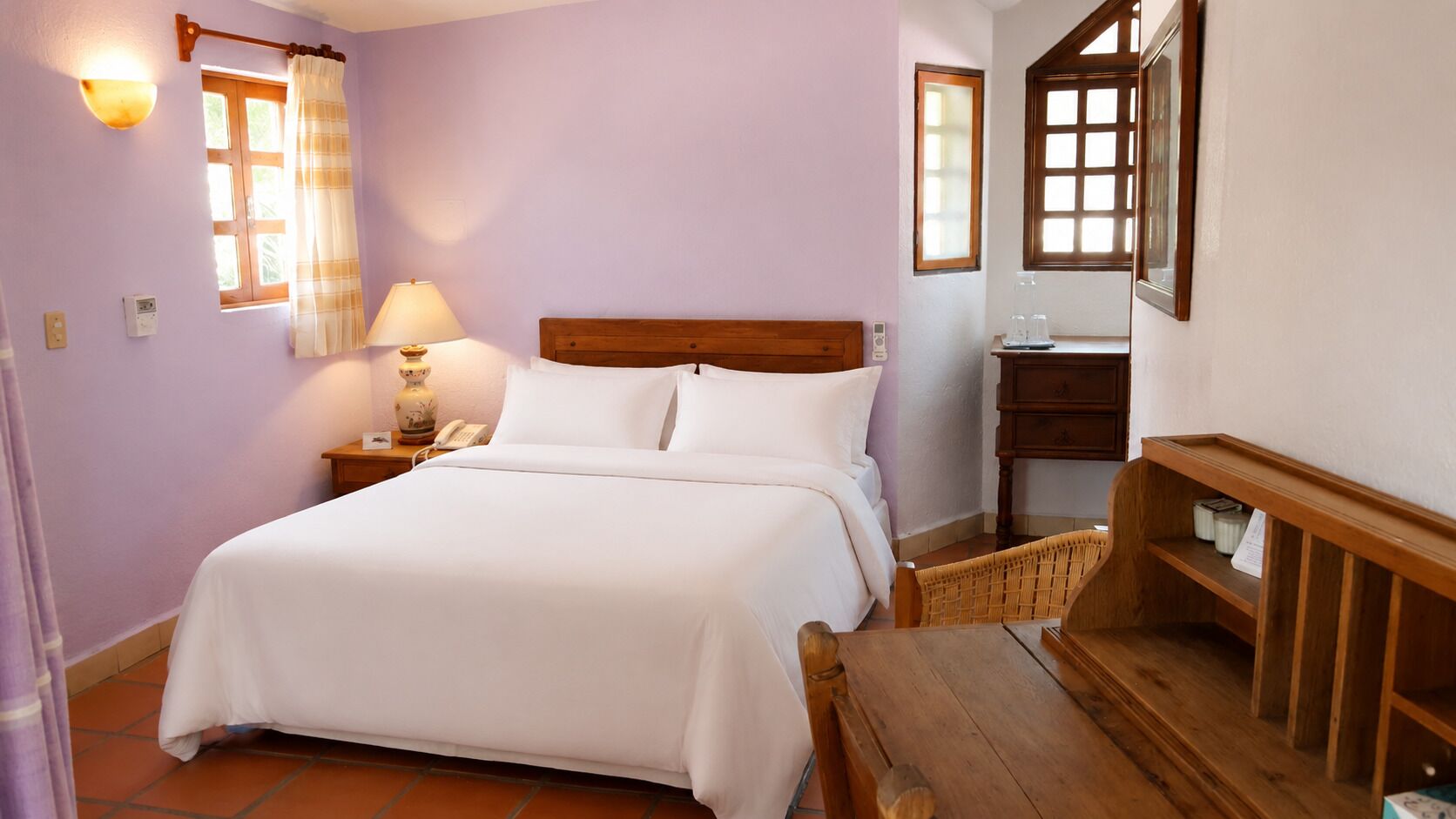 Une chambre à coucher avec un lit, une table de chevet, une lampe et une chaise en bois.