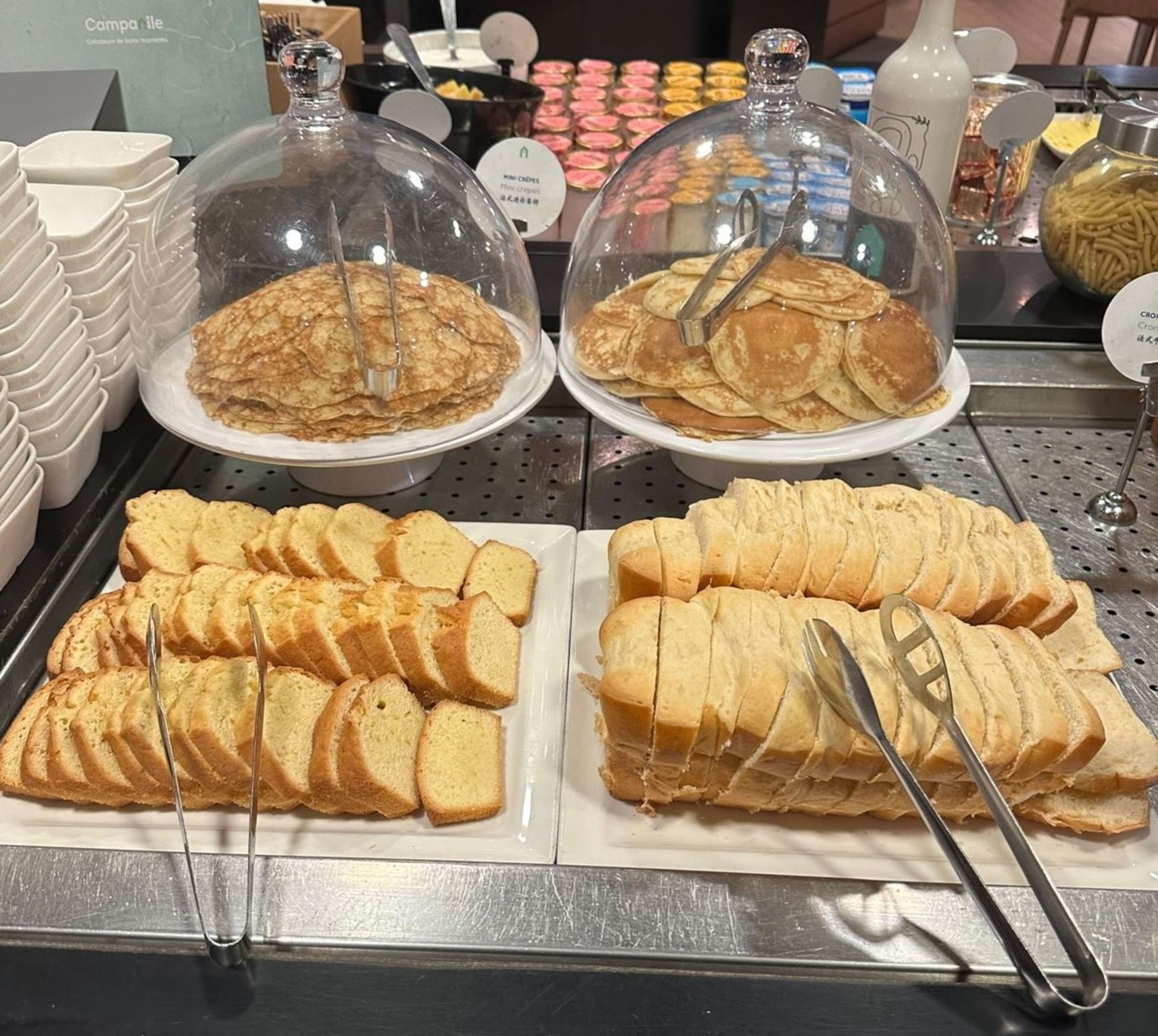 A breakfast buffet with various pastries and bread.