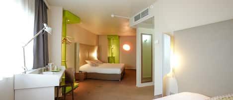 Een hotelkamer met een bed, een bureau, een stoel en een nachtkastje.