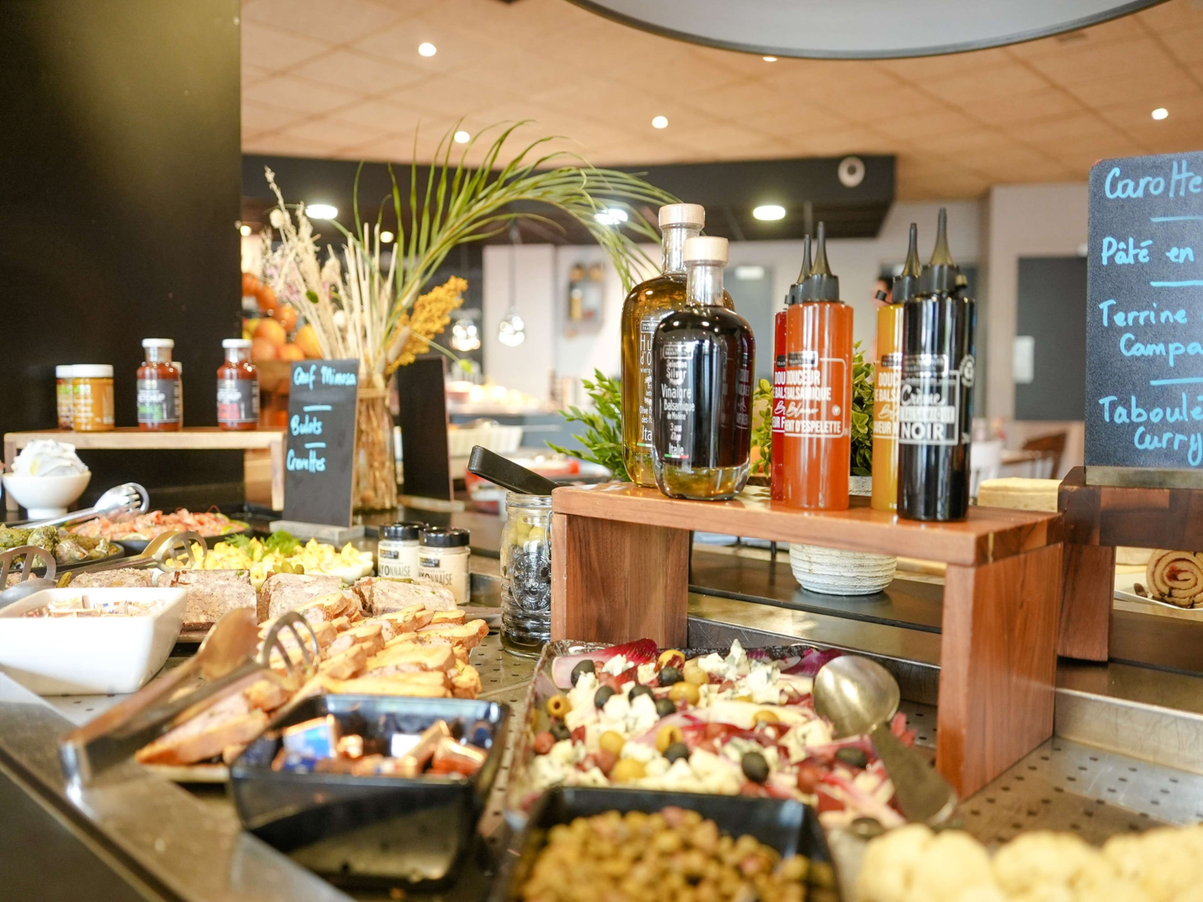 A buffet with various food items and condiments.