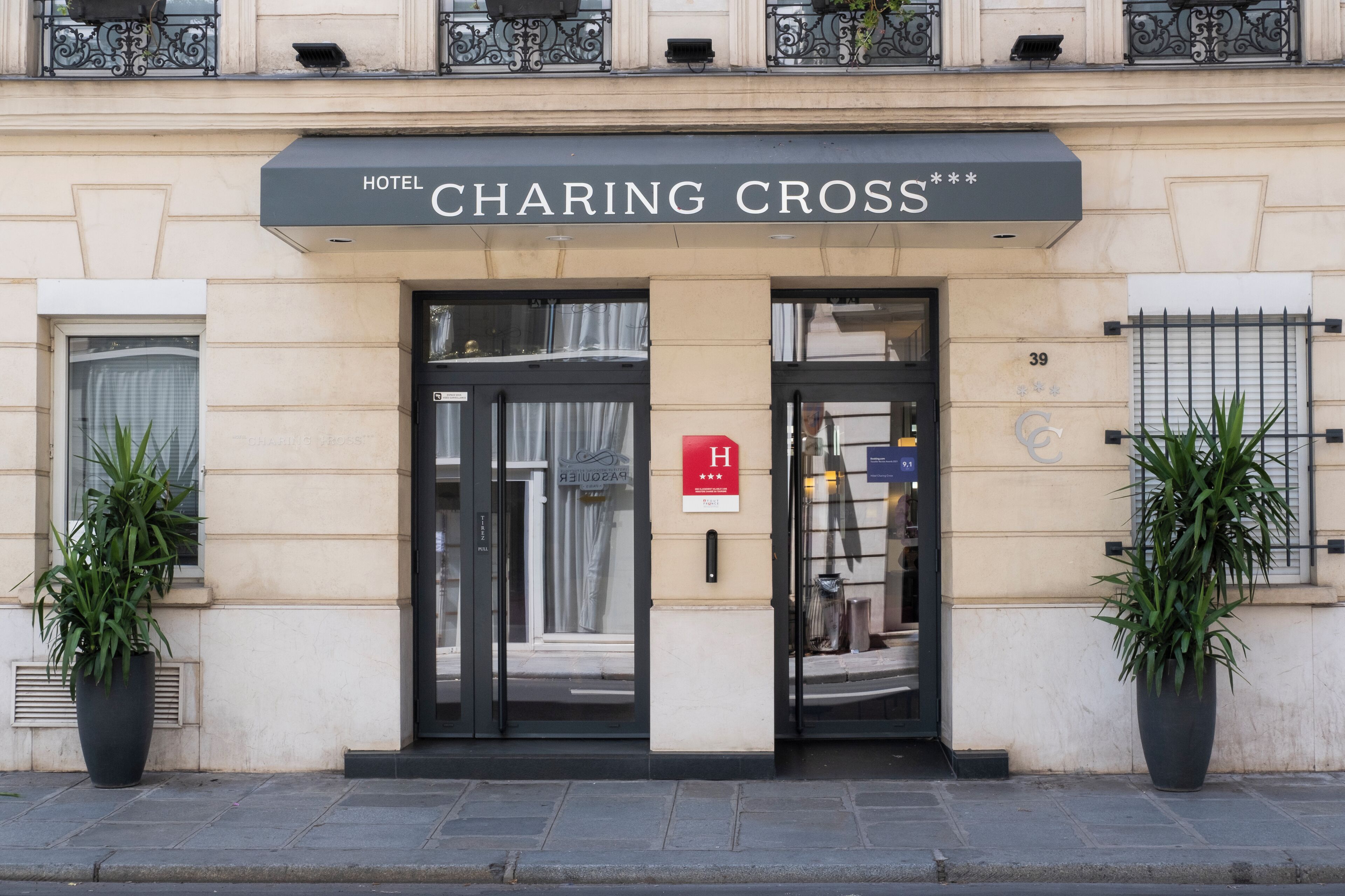 L’entrée d’un hôtel, avec une enseigne indiquant « HÔTEL CHARING CROSS ».
