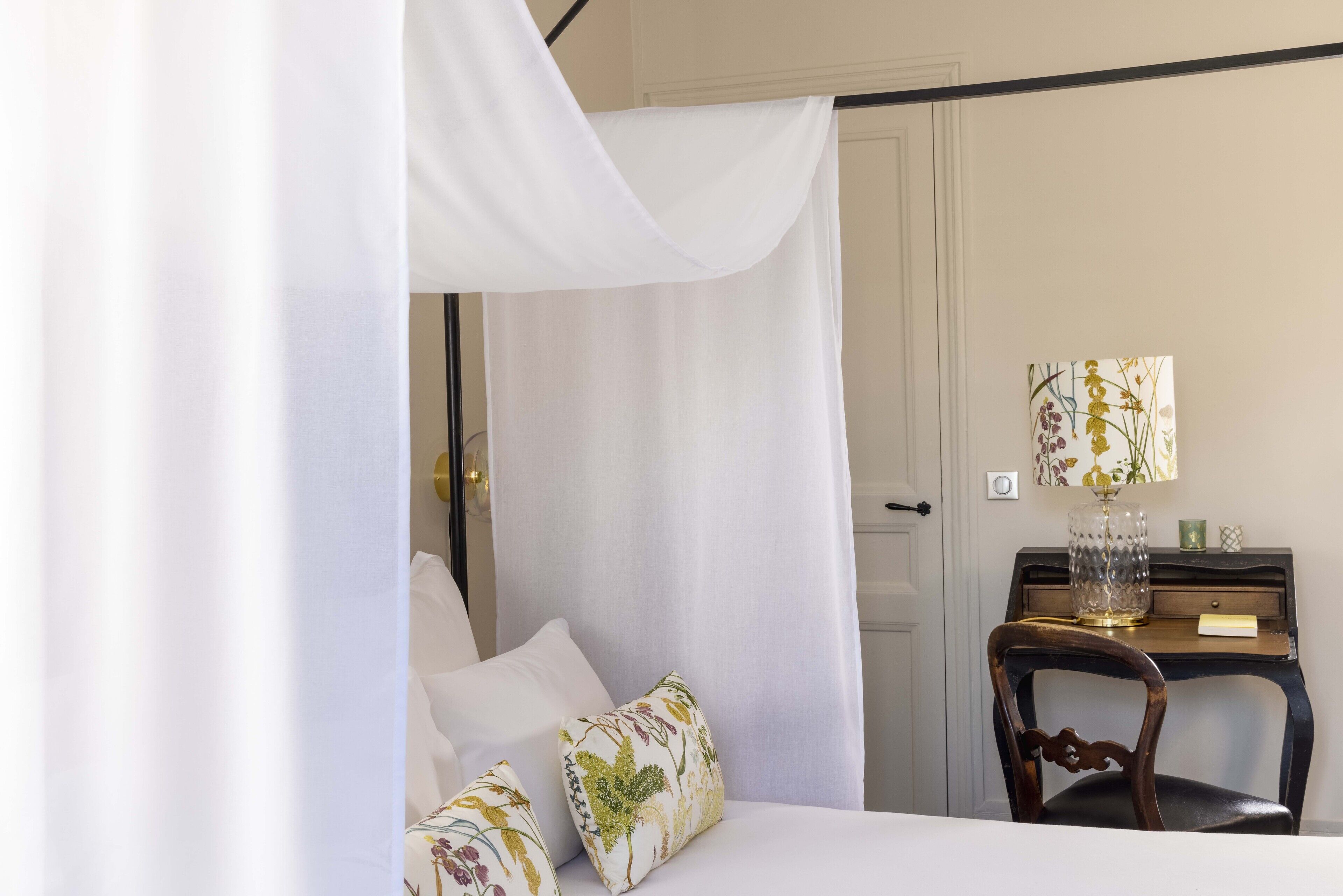 A bedroom with a bed, a desk, and a chair.