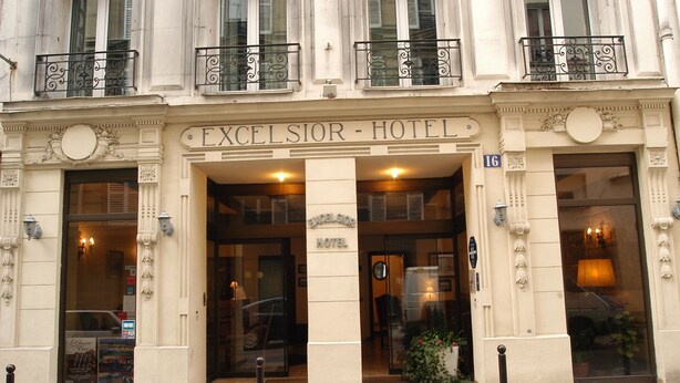 The exterior of the Excelsior Hotel with a classic facade, large windows, and a sign indicating the entrance. - Hotel Excelsior Batignolles (Paris)