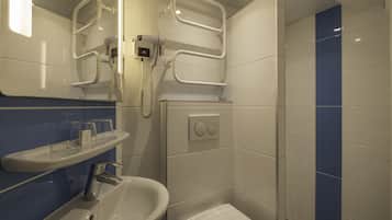 Un baño con lavamanos, espejo, toallero y zona de ducha.