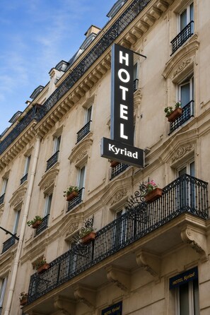 A hotel sign with the name 'HOTEL Kyriad' on a building facade.
