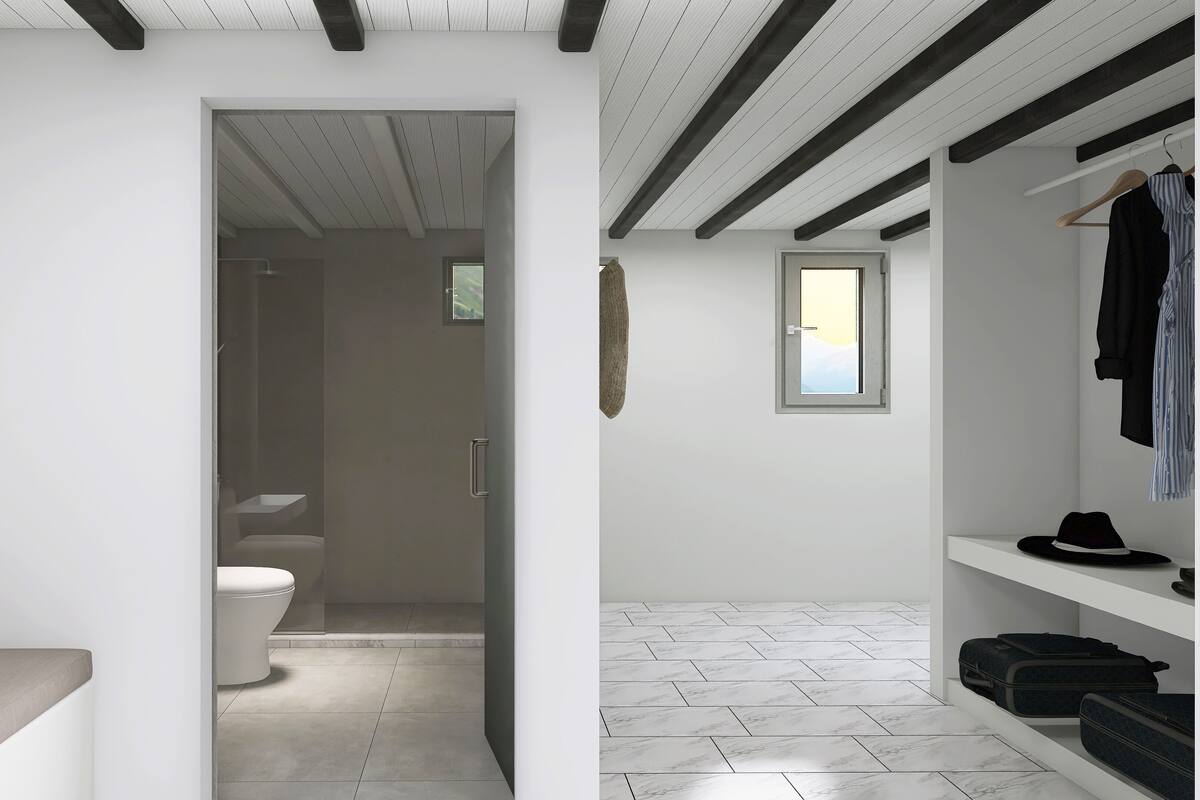 Un baño moderno con inodoro, ducha y lavabo. Hay un banco con almohada, un banco de madera y un estante con ropa y un sombrero.