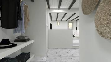 Un couloir avec un sol blanc, un plafond aux poutres apparentes et un lit visible au loin.