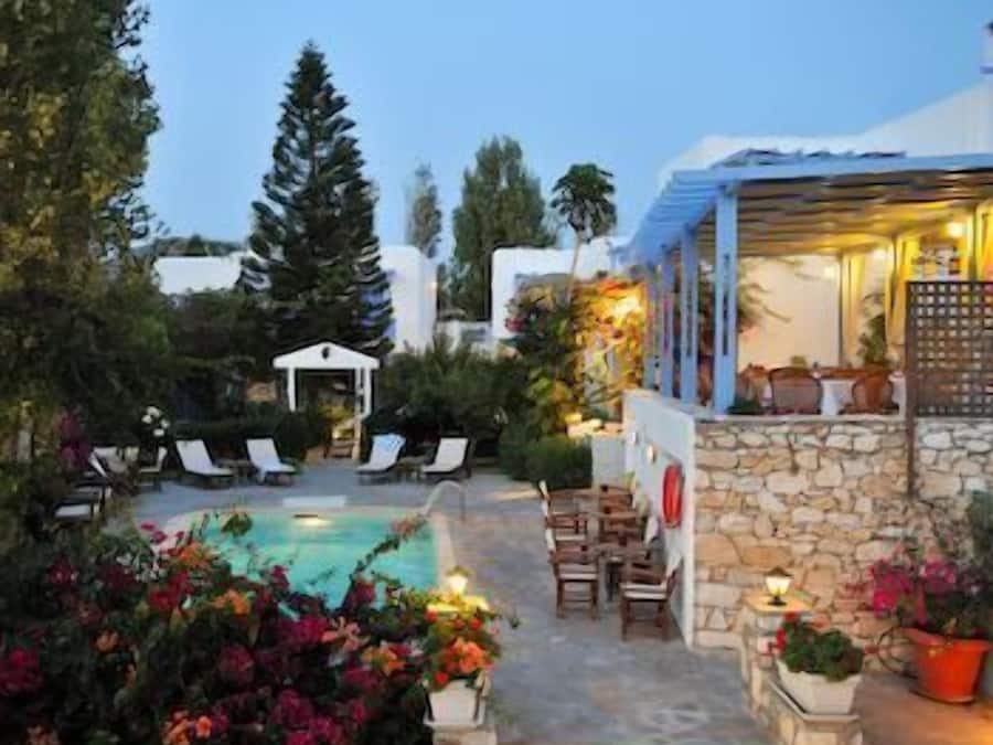 Una piscina al aire libre, sombrillas, sillones reclinables de piscina