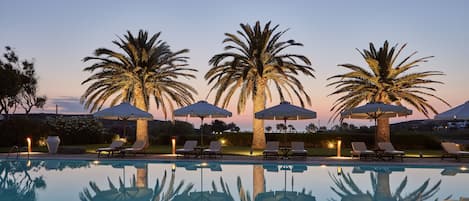 Een buitenzwembad, parasols voor strand/zwembad