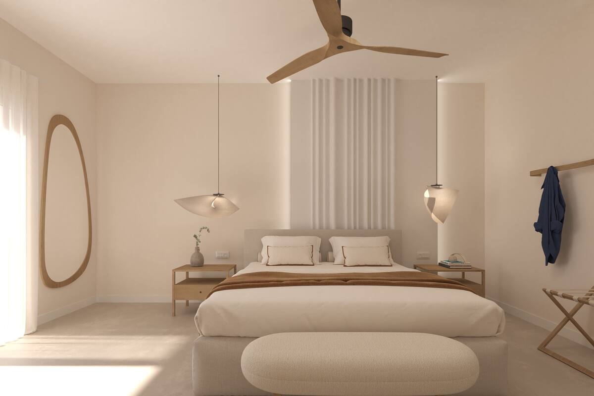 Une chambre à coucher moderne avec un grand lit, des tables de chevet, un ventilateur de plafond et un luminaire suspendu.
