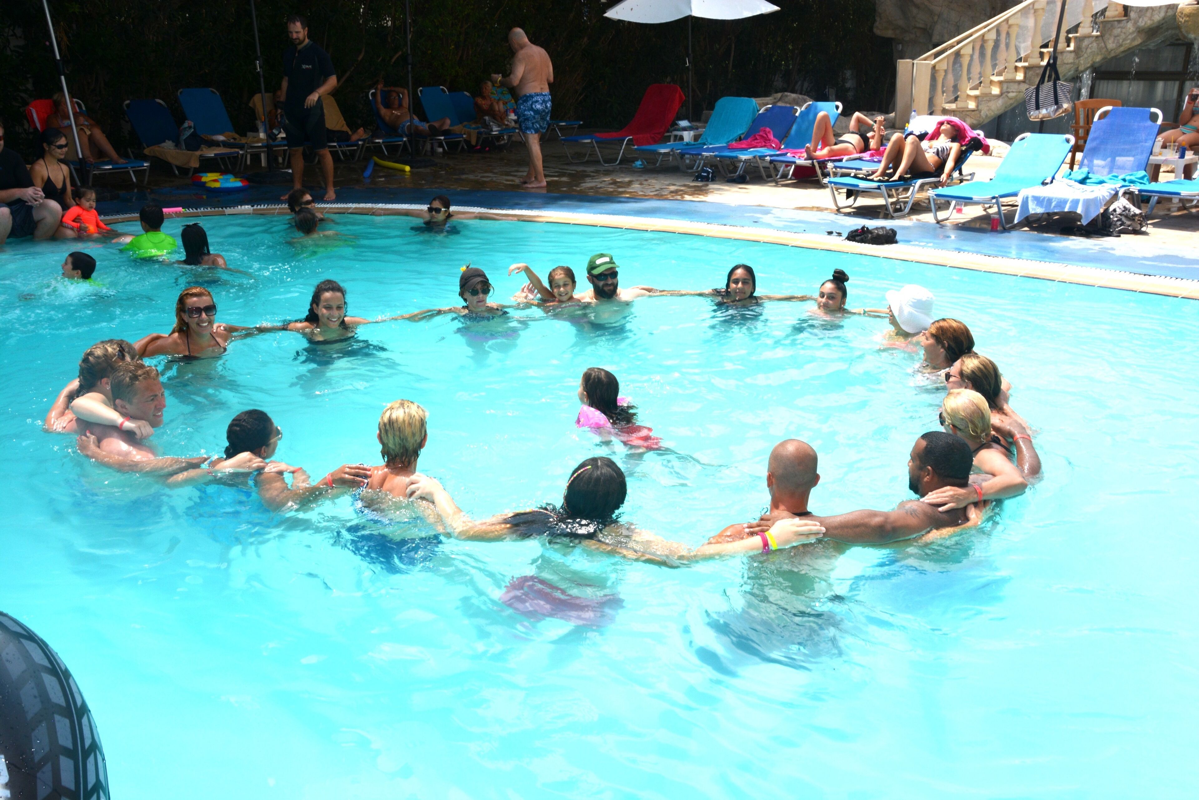 A swimming pool with people holding hands in a circle.