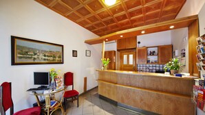 Un área de recepción con un mostrador de madera, una computadora y una silla.