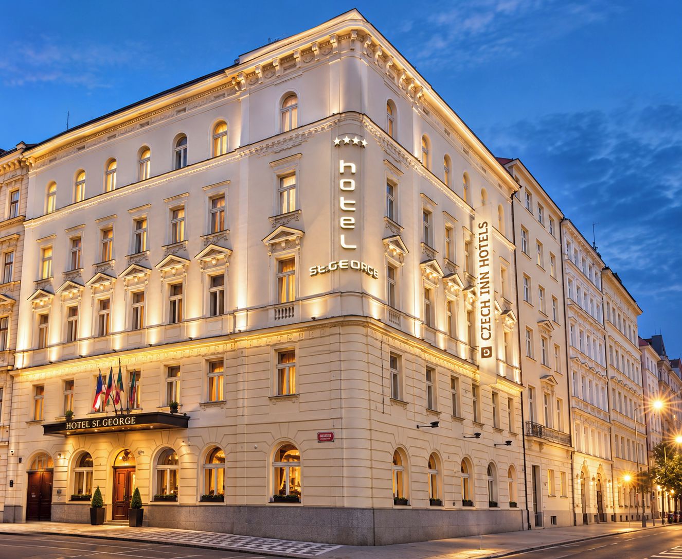 A historic hotel building with a classic architectural style, featuring multiple stories, arched windows, and a prominent signage for 'HOTEL ST. GEORGE'.
