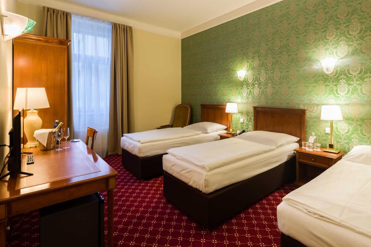 Driepersoonskamer | Een minibar, een kluis op de kamer, een bureau, een laptopwerkplek