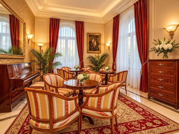 Un comedor elegante con un piano, sillas a rayas, una mesa redonda y una alfombra roja.