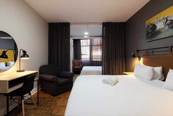 A hotel room with a bed, desk, chair, and a painting on the wall. - Hotel 224 and Apartments (Pretoria)