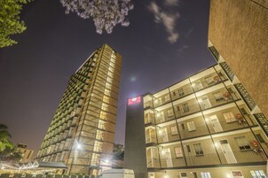 Un edificio de varios pisos con un diseño arquitectónico moderno, con balcones y ventanas amplias.