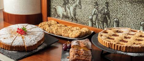 Una presentación de postres con pasteles y galletas sobre una mesa de madera.