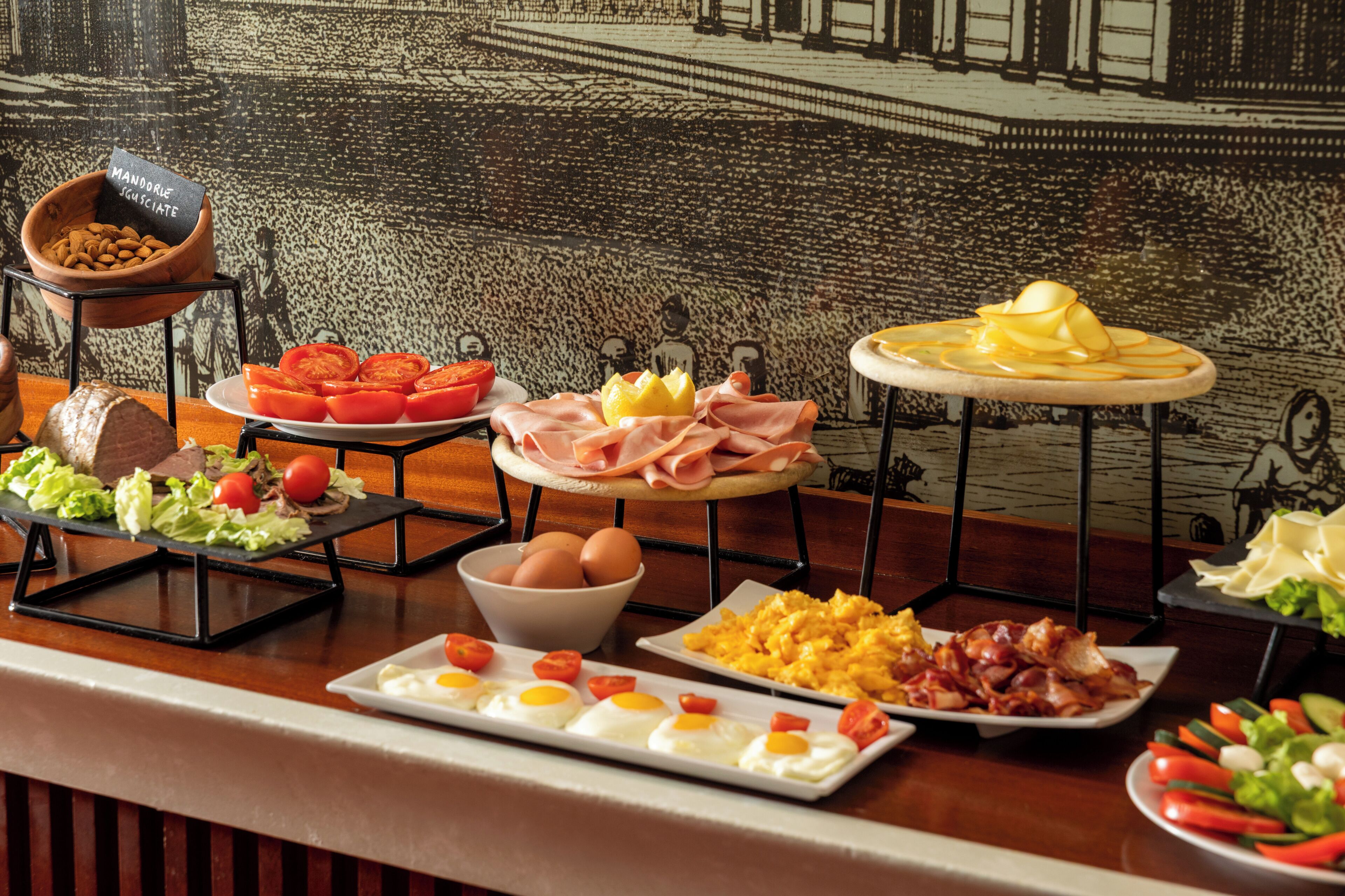 Een ontbijtbuffet met diverse gerechten, zoals eieren, spek en groenten.