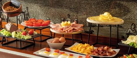 A breakfast buffet with various food items including eggs, bacon, and vegetables.