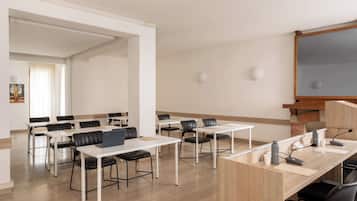 A conference room with white tables, black chairs, a wooden podium, and a whiteboard.