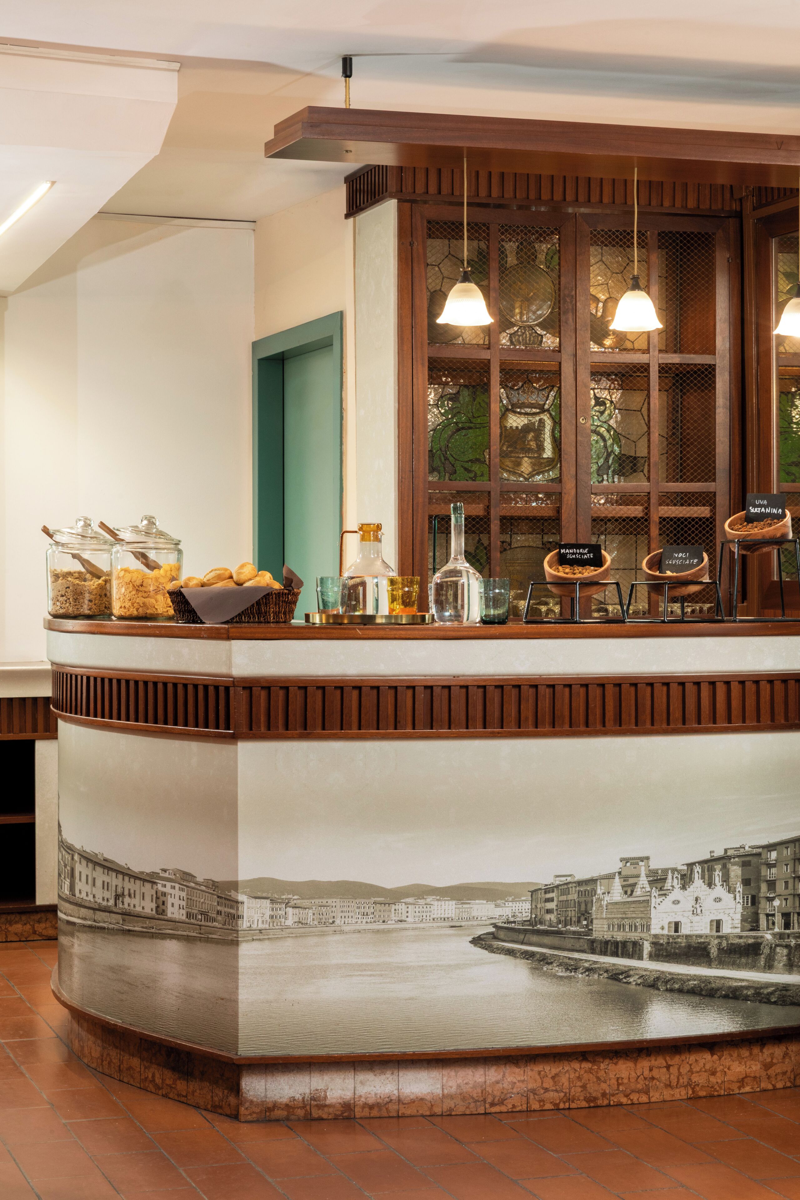 A counter with food and drink options, a view of a cityscape through a window, and a decorative wall.