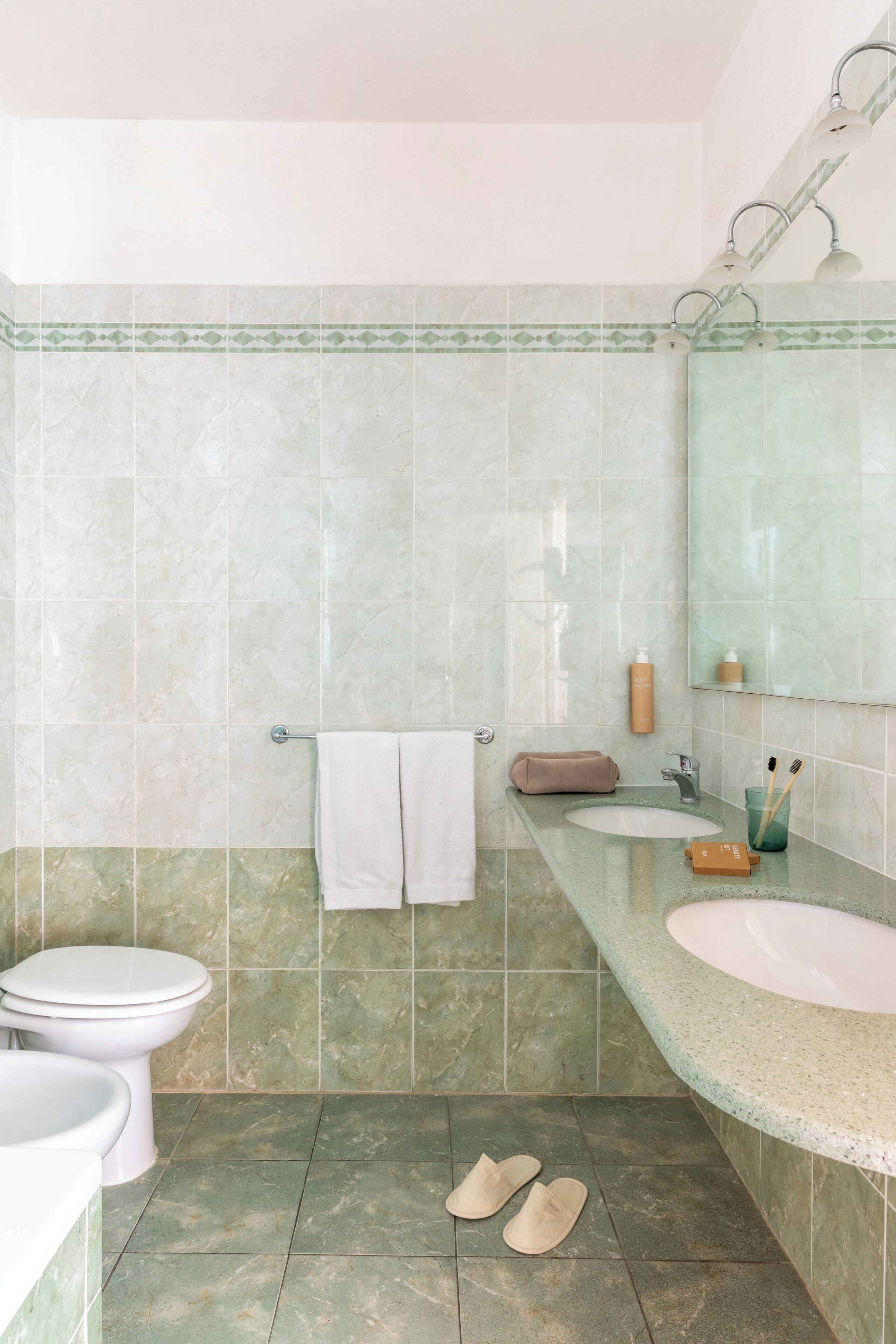A bathroom with two sinks, a toilet, and a shower.