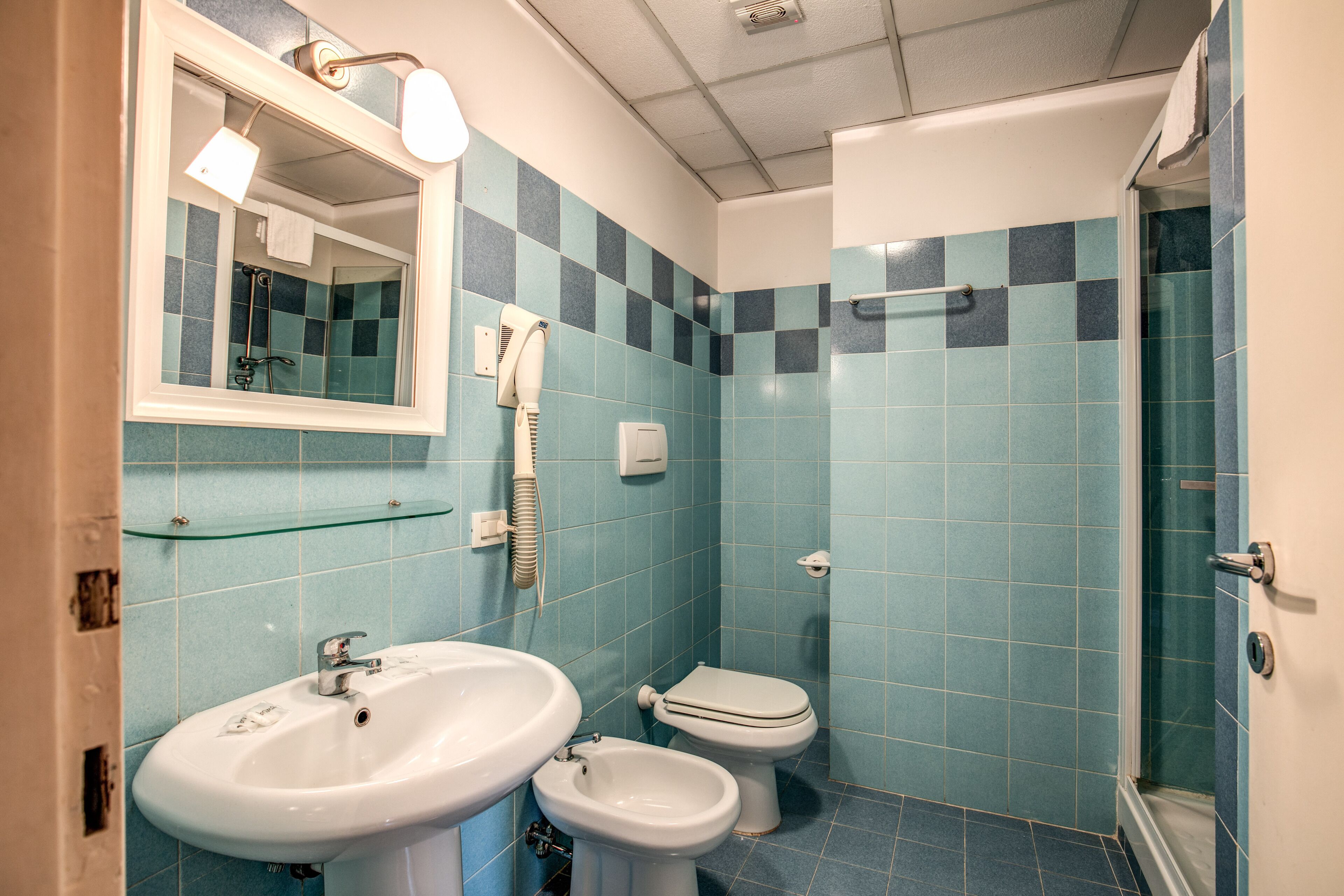 A bathroom with a sink, bidet, and toilet.