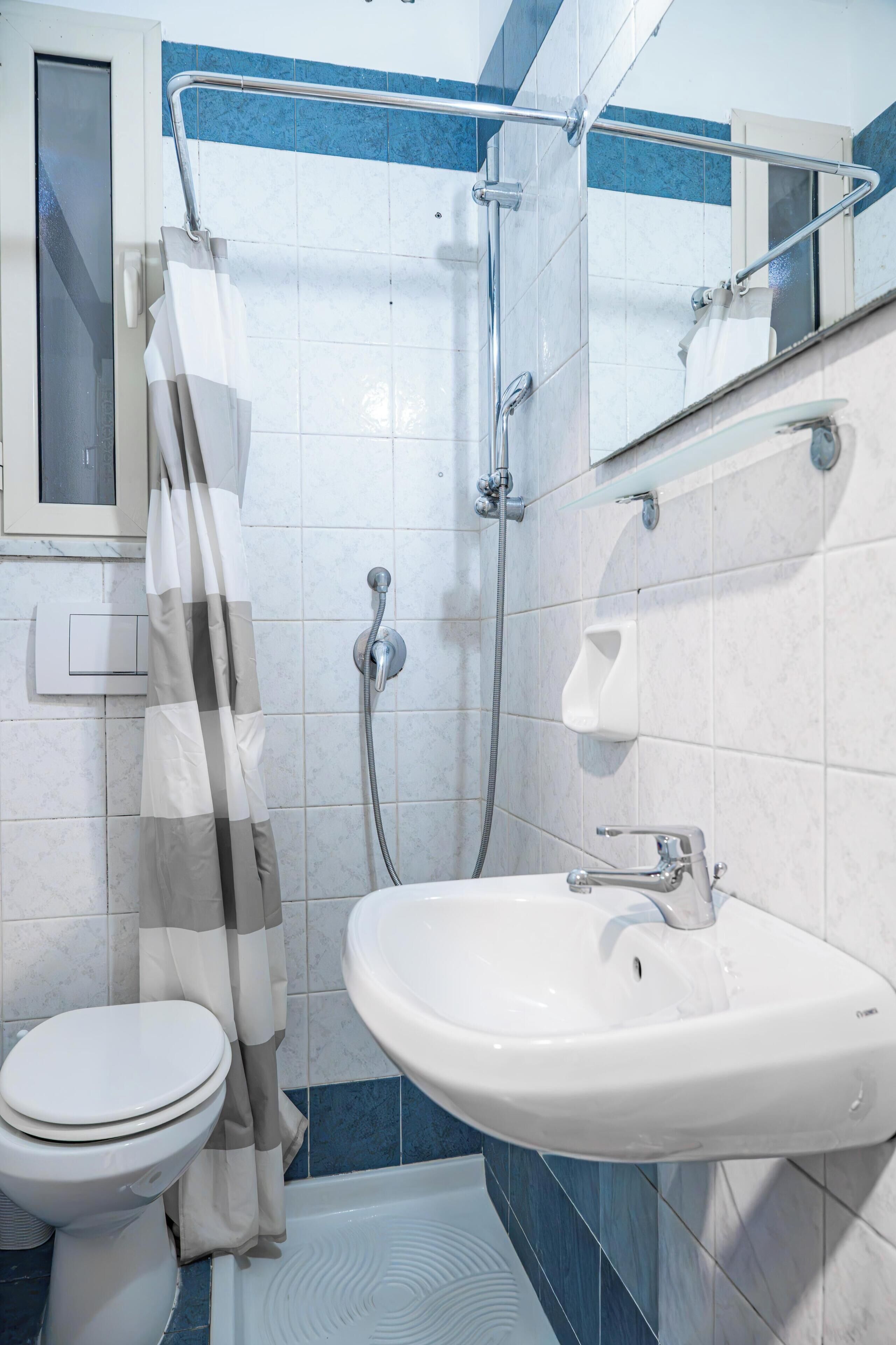 Un baño con inodoro, ducha y lavamanos.
