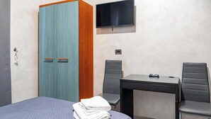 A hotel room with a bed, a desk with two chairs, a television, and a wardrobe. - Hotel Planet (Rome)