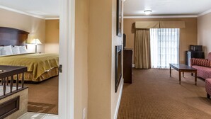 A hotel room with a bed, a desk, a TV, and a sofa. - Quality Inn near Hearst Castle (San Simeon)