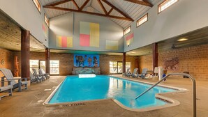 Una piscina interior con un cartel de 'No Diving', sillones de descanso y un mural en la pared.