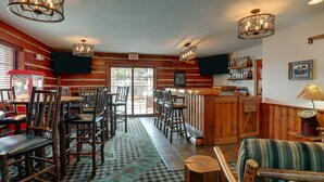 Un restaurante con paredes de madera, una zona de bar y diferentes opciones de asientos.
