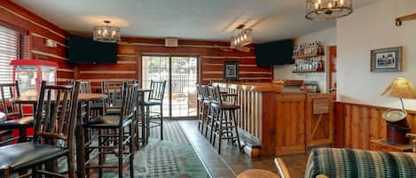 A restaurant with wooden walls, a bar area, and multiple seating arrangements.