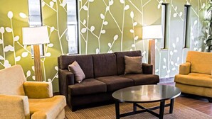 A modern living room with a brown sofa, two armchairs, and a coffee table. - Sleep Inn & Suites Virginia Horse Center (Lexington)