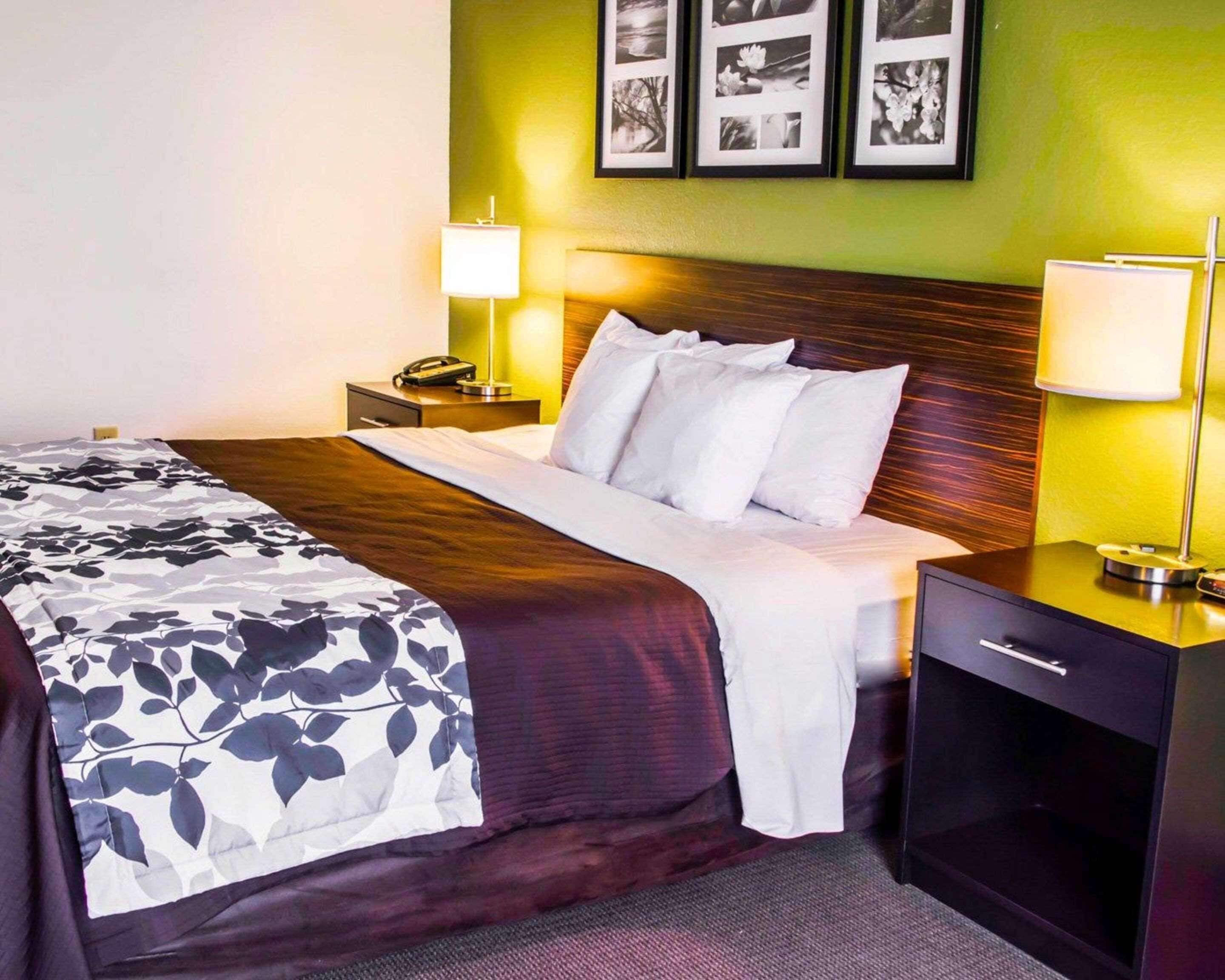 A neatly made bed with a floral bedspread, a wooden headboard, and two bedside lamps.