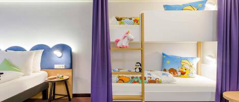 A children's room with bunk beds, a small table, and a sofa.