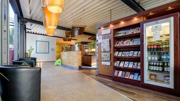 A reception area with a wooden reception desk, a magazine rack, and a beverage refrigerator.