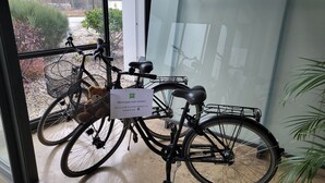 Two bicycles with baskets, one with a teddy bear, and a sign in German. - ibis Styles Leipzig (Schkeuditz)