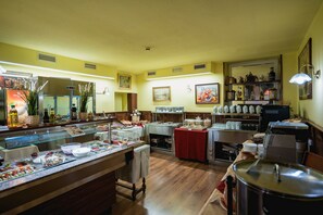 Montaje de buffet con diversas opciones de comida y una máquina de café.