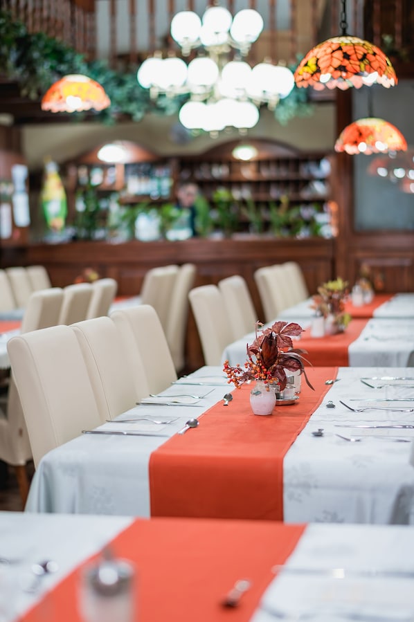 A restaurant with long tables, red tablecloths, and decorative vases. - Hotel Unio Budapest (Budapest)