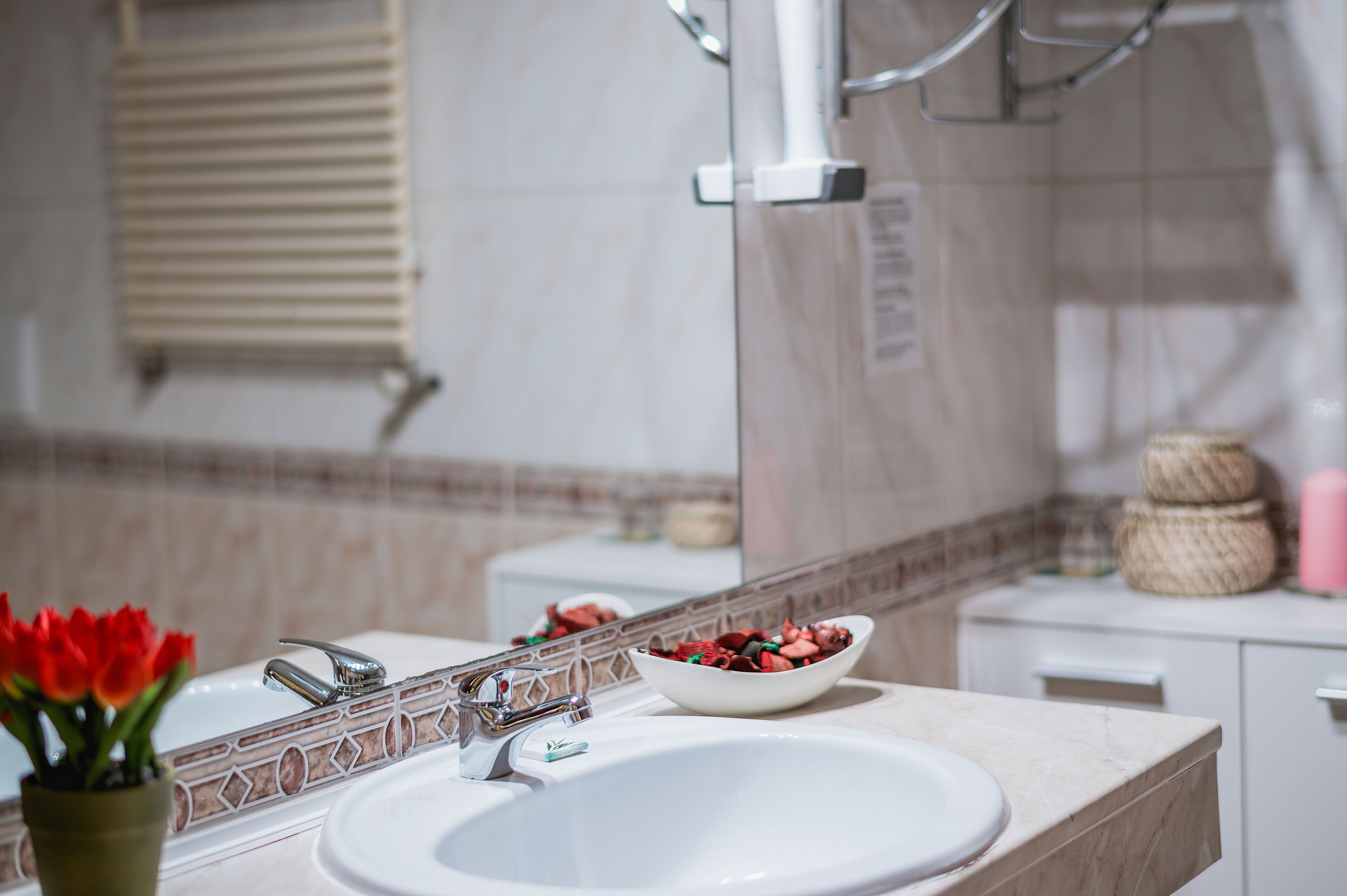 A bathroom with a white sink, a mirror, and a towel rack.