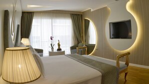 Une chambre d’hôtel moderne dotée d’un grand lit, d’un téléviseur fixé au mur et d’un design de plafond original.