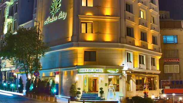 L’hôtel Arden City, reconnaissable à son grand panneau néon, à son entrée bien éclairée et à son escalier bien visible qui mène au hall d’entrée.