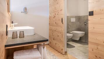 Een moderne badkamer met een houten wastafelmeubel, een wastafel en een toilet.